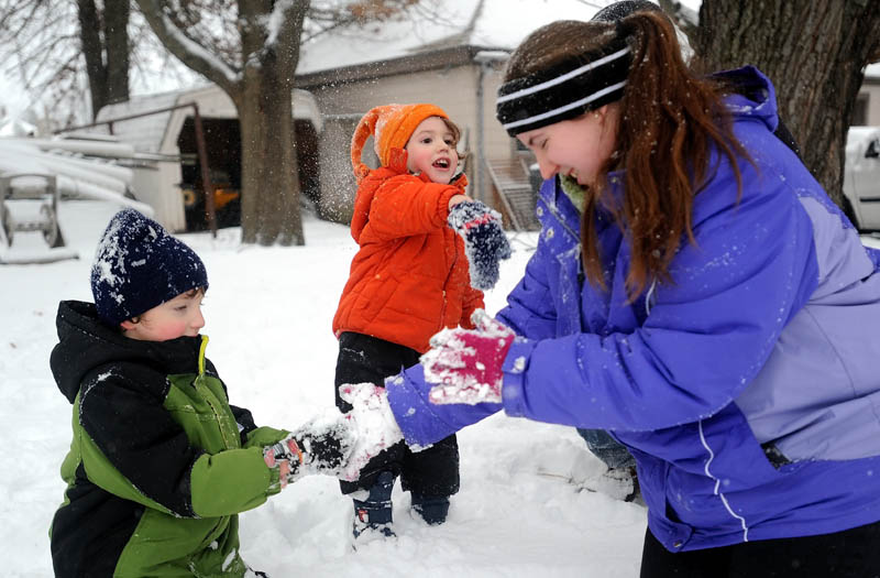 J.J. Burns, 2, center, pelts his mother, Melissa, with a snowball as she helps his big brother, Ian, 5, make a snowball during a winter storm on St. John Street in Winslow on Thursday.