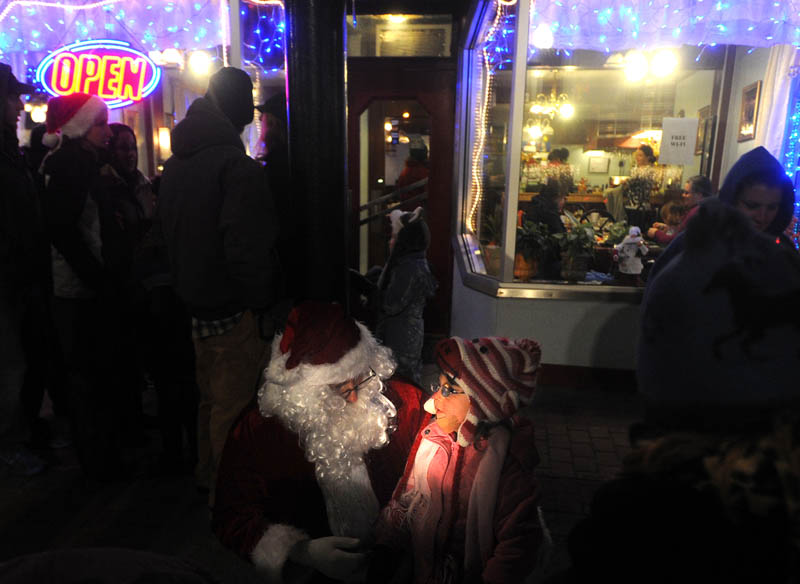 Santa Claus listens carefully to Laura Harding, 3, of Harmony, offer a list of gifts she would would like to see under her Christmas tree this year, while at the Parade of Lights on Water Street in downtown Skowhegan earlier this month.