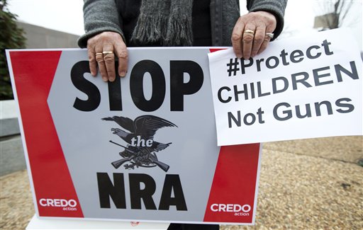 A protester holds a banner during a march to the National Rifle Association headquarters in Washington Monday.