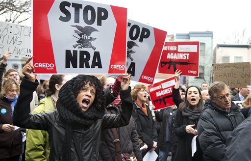Tasha Devoe, left, of Lawrence, Mass., joins a march to the National Rifle Association headquarters on Capitol Hill in Washington on Monday. After four days of self-imposed silence on the shooting that killed 26 people inside a Newtown, Conn., elementary school, the nation's largest gun rights lobby emerged Tuesday and promised "to offer meaningful contributions to help make sure this never happens again."