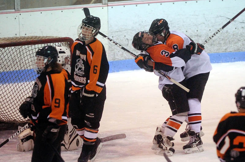 CELEBRATE: Skowhegan High School teammates Kyle Demchak, 3, and Chase Nelson, 8, celebrate Demchak’s goal in the first period at Sukee Arena in Winslow on Wednesday.