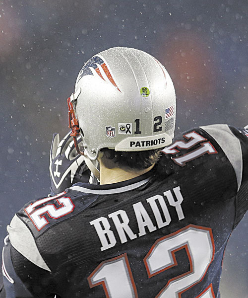 REMEMBERING: A sticker showing a black ribbon to honor the victims of the Sandy Hook Elementary School shootings in Newtown, Conn., is affixed to the helmet of New England Patriots quarterback Tom Brady before a game against the San Francisco 49ers on Sunday night in Foxborough, Mass.