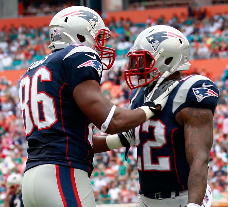 Tight end Daniel Fells, left, congratulates running back Stevan Ridley after Ridley scored a touchdown in the first quarter Sunday against the Dolphins at Miami. The Patriots won, 23-16.