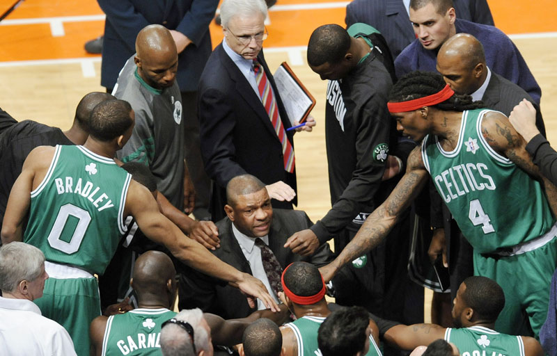 LET’S START LATER: The Boston Celtics gather around coach Doc Rivers during the first quarter of their game against the New York Knicks last Christmas at Madison Square Garden in New York. The league started late last season out of necessity following the lockout, but Rivers and others think it’s something the NBA should consider doing regularly, to create more anticipation and separate itself further from the football season.