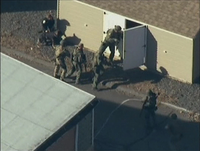 Police search a building after the shooting at Sandy Hook Elementary School in Newtown, Conn., on Friday, Dec. 14. The president of the Maine Gun Owners Association says teachers with firearms training should be allowed to carry guns following the Connecticut shooting in which 20 elementary school children were killed.