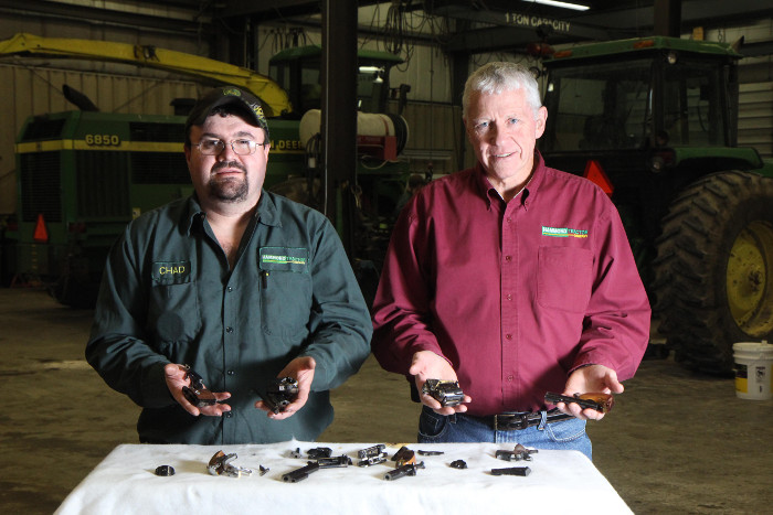 Hammond Tractor Company co-owner Gary Hammond, right, and employee Chad Tibbetts hold pieces of destroyed firearms in Fairfield on Friday. In the wake of the Newtown, Conn. shooting, Hammond Tractor – a hunter and gun owner – was offering to accept and destroy firearms from local citizens. He has since rescinded that offer.