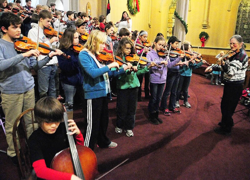 Betsy Kobayashi, right, leads a rehearsal of Pineland Suzuki School on Friday night at South Parish Congregational Church in Augusta. The group will perform two benefit concerts, at 2 p.m. on Saturday at the Duke Albanese Performing Arts Center at Messalonskee High School in Oakland and at 2 p.m. Sunday at South Parish Congregational Church, off State Street in Augusta.