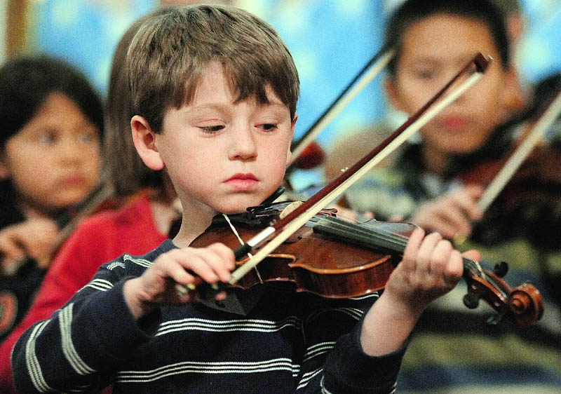 Ben Sheaffer plays his violin during a rehearsal of Pineland Suzuki School on Friday night at South Parish Congregational Church in Augusta.