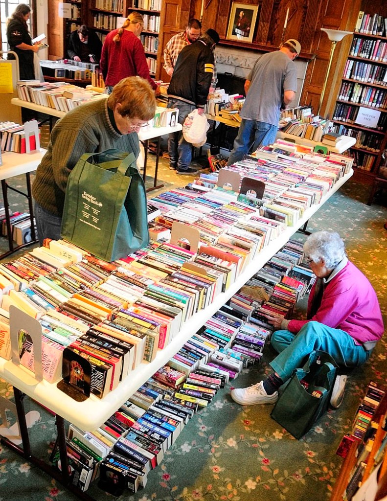Nan Spaulding, standing left, and Mary Perkins, seated right, look for books to buy on Monday morning at the Gardiner Public Library. Monday was a "buck-a-bag" sale day following the semiannual book sale held on Saturday. The next one will be held in June 2013, according to Library Director Anne Davis.