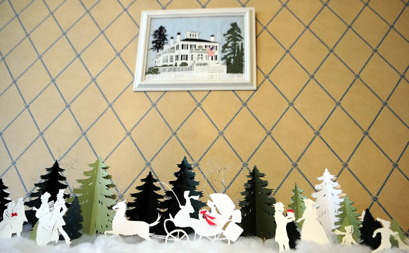 Cynthia Herrick made the picture of the Blaine House and the decoration on the table from cut paper, on display in the family dining room at the Blaine House on Tuesday in Augusta.