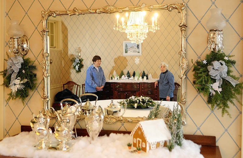 Cynthia Herrick, left, and Jean Wave decorated the family dining room on Tuesday at the Blaine House in Augusta.