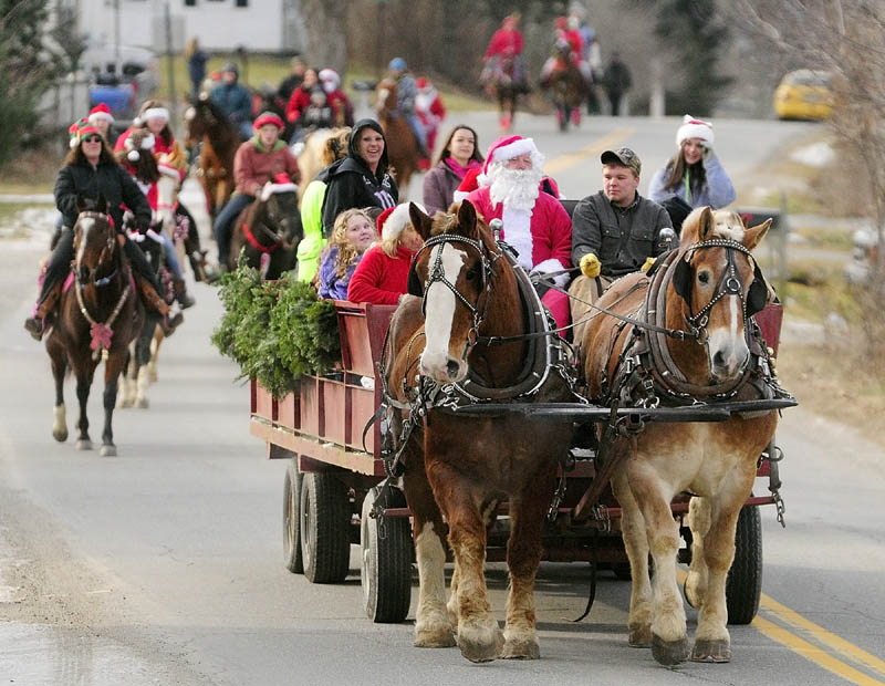 Riding in a wagon, Santa Claus leads the 6th annual Hemphill's Christmas parade down Oak Grove Road on Sunday, in North Vassalboro. The parade started from Hemphill's stables, proceeded down Oak Grove Road to Route 32, went around a block and returned to the farm, where there was a contest for the best costumed horses and riders.