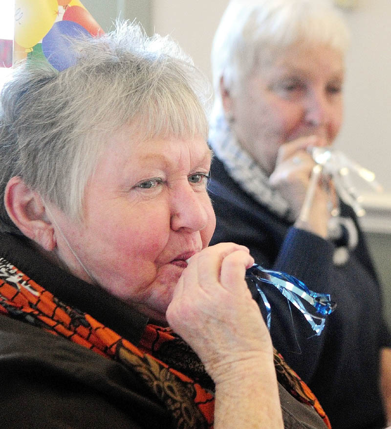 Joani Gavett, left, and Nancy Bunker, both of Mount Vernon, ring in the New Year by blowing noisemakers at noon on Monday at the Cohen Center in Hallowell. Organizers said noon here corresponded with midnight in Indonesia. About a 100 people attended the New Year's luncheon.