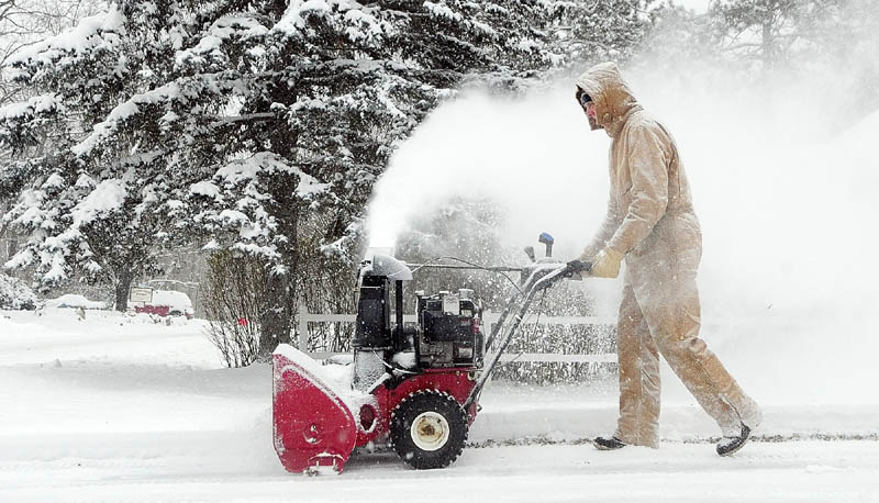 Larry Morrissette clears the driveway with a snow blower Monday morning in Hallowell, where at least 5 or 6 inches of snow had fallen overnight.