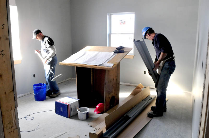 Art O'Brien, left, and Richard Hjort work on the Winslow police chief's office on Thursday.