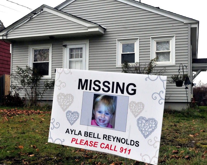 A sign and photograph of Ayla Reynolds has been placed in front of 29 Violette Ave. in Waterville, where she was reported missing nearly a year ago.