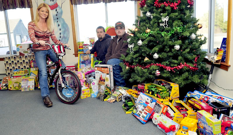 Charlie & Sons Used Cars and Chuck's Auto Recovery & Towing have collected money and toys for Madison area children this holiday season. Inside the Madison business are Kristina Willette, Ken Ashe and owner Charlie Robbins.