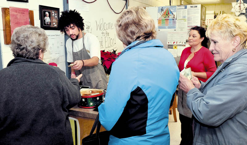 Culinary student Dallas Hutchinson takes payments from people who dined at the popular The Food Place, at Skowhegan Area High School, on Tuesday. Looking on at right is education technician Janelle Saucier.