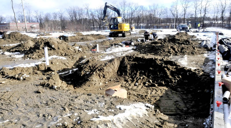 Workers prepare plumbing connections before a foundation is poured for the new Waterville police department building on Thursday.