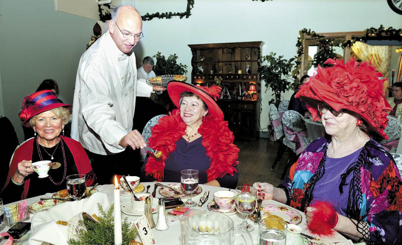 Roger Gagne serves members of the Foxy Gals chapter of the Red Hat Society during a Vintage Tea, at the Forum in Waterville on Sunday. Fine foods, entertainment and raffles were enjoyed. From left are Shirley Chaffee, Mary Audet and Jo Ann Eichorst.