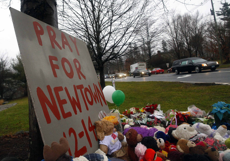 A hearse carrying the casket of of six-year-old Jack Pinto passes a makeshift memorial on its way to Newtown Village Cemetery in Newtown, Connecticut. (Reuters / Eric Thayer)