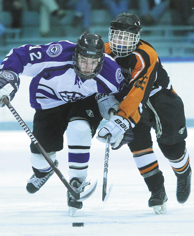 HOLDING HIM BACK: Waterville Senior High School’s Tommy Samson holds off Winslow High School’s Dameron Rodrigue while skating the puck up ice during the second period Tuesday at Colby College in Waterville.
