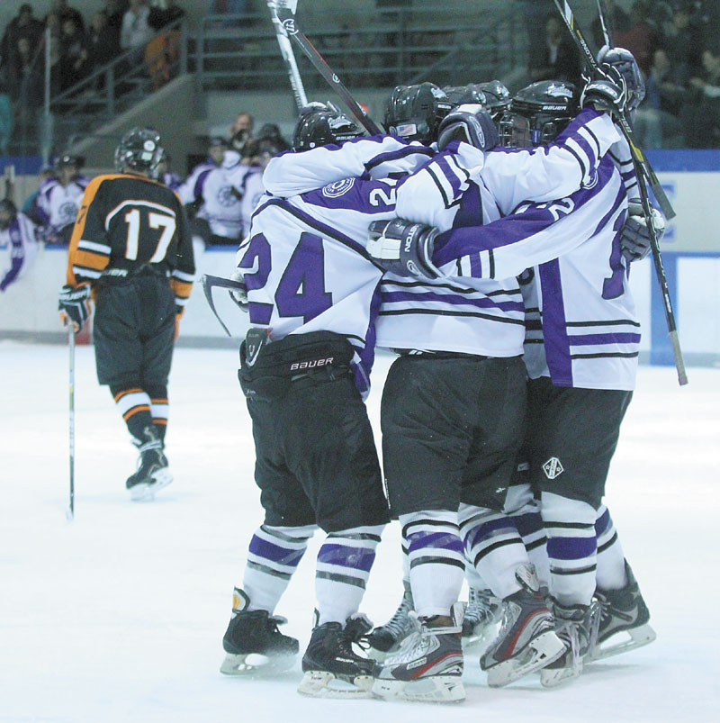 A REASON TO CELEBRATE: Waterville Senior High School’s Edward Atkins is congratulated by teammates after scoring a second-period goal during the Panthers’ 6-2 win over Winslow High School on Tuesday night in Waterville.