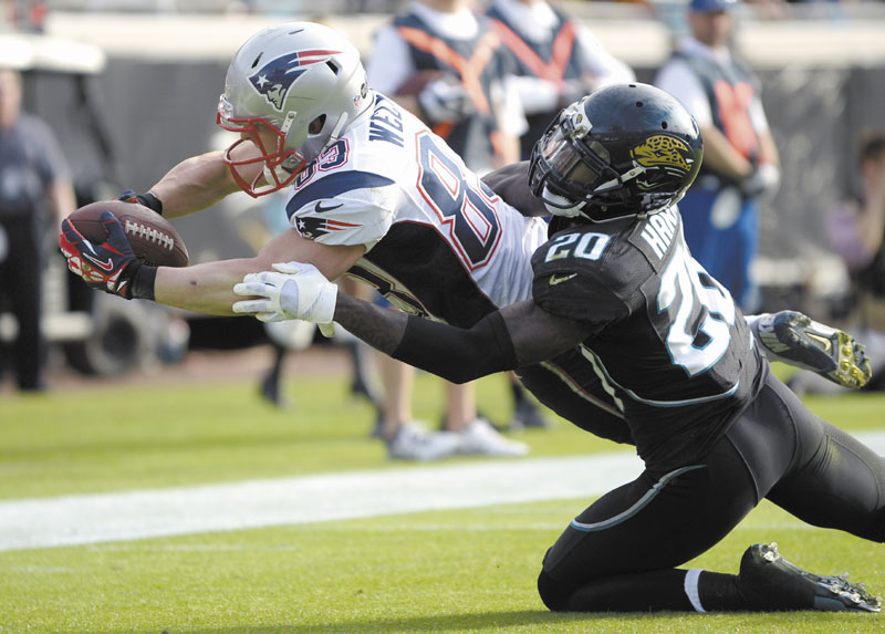 NICE EFFORT: New England Patriots wide receiver Wes Welker (83) dives over the goal line past Jacksonville Jaguars cornerback Mike Harris (20) for a touchdown on a 2-yard pass play during the Patriots’ 23-16 win Sunday in Jacksonville, Fla. NFLACTION12;