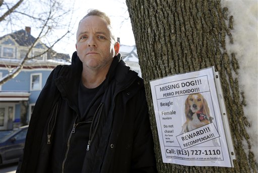 Author Dennis Lehane stands next to a poster for his missing dog in Brookline, Mass., Thursday, Jan. 3, 2013. The dog, a beagle named Tessa, went missing on Christmas Eve 2012. (AP Photo/Steven Senne)