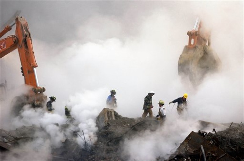 In this Oct. 11, 2001 file photo, firefighters make their way over the ruins of the World Trade Center through clouds of dust and smoke at ground zero in New York. The special fund set up by Congress to compensate people who fell ill after being exposed to ash and dust from the World Trade Center is making its first round of payments, more than two years after the money was appropriated. (AP Photo/Stan Honda, Pool, File)