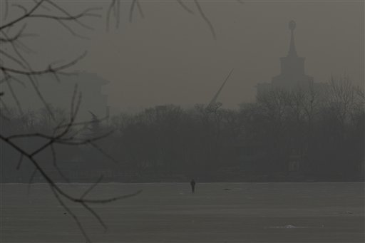A man walks on an frozen lake on a hazy day in Beijing, China on Monday.