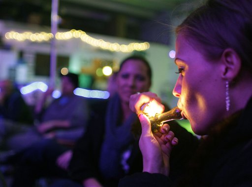 Rachel Schaefer of Denver smokes marijuana at the official opening of Club 64, a marijuana social club, where a New Year's Eve party was held on Monday.