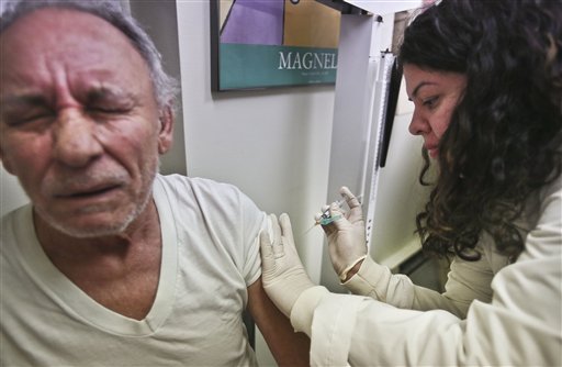 Carlos Maisonet, 73, reacts as Dr. Eva Berrios-Colon, a professor at Touro College of Pharmacy, injects him with flu vaccine during a visit to the faculty practice center at Brooklyn Hospital in New York on Tuesday.