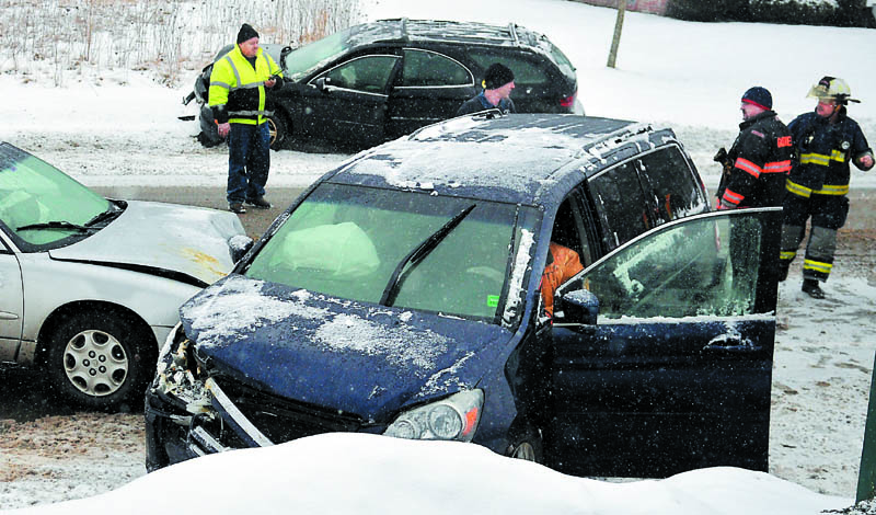 Farmingdale and Gardiner firefighters approach vehicles that collided Wednesday on Maine Avenue in Farmingdale. Accidents were reported across Maine as several inches of snow fell.