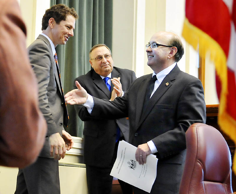 Matt Dunlap, right, greets Maine Senate President Justin Alfond, left, after being sworn in as secretary of state on Monday, in Augusta, by Gov. Paul LePage.