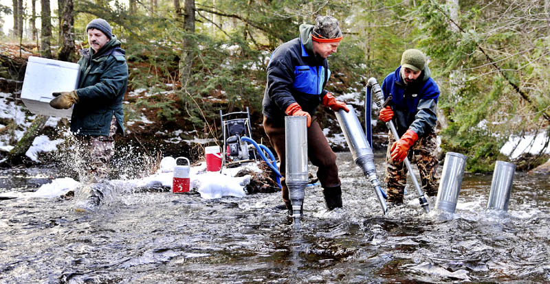 Department of Marine Resources biologist Jason Overlock, right, drills a redd for salmon roe Tuesday, as his colleague, Jason Bartlett, center, places a funnel for biologist Paul Christman, left, to insert Atlantic salmon eggs into the bed of the Sheepscot River in Palermo. DMR is using a novel technique, of blasting the bottom of the river with a high-pressure hose, to create the proper environment for inseminated eggs to hatch.
