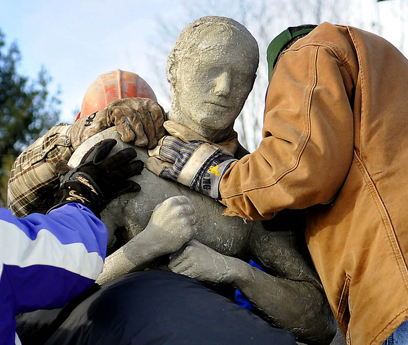 People attach a concrete human figure Sunday, while installing a sculpture at the Viles Arboretum in Augusta, which was created by University of Maine at Augusta students.