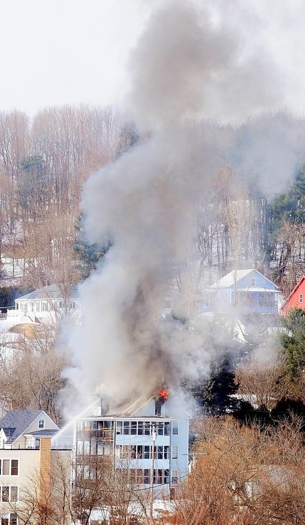 Smoke pours from the roof of 1 Penobscot St. at 12:48 p.m. Tuesday in this photo taken from the east side of Augusta.