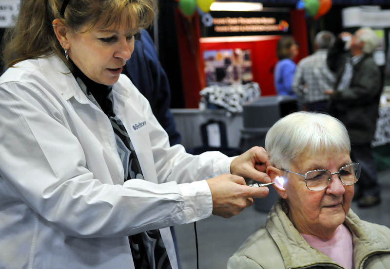 Christine Gay, of Vassalboro, gets her hearing checked Wednesday by Lisa King, of Beltone, during the Maine Agricultural Trades Show in Augusta. The free hearing checkup for guests was provided by Maine AgrAbility, which assists farmers with chronic health issues across the state.