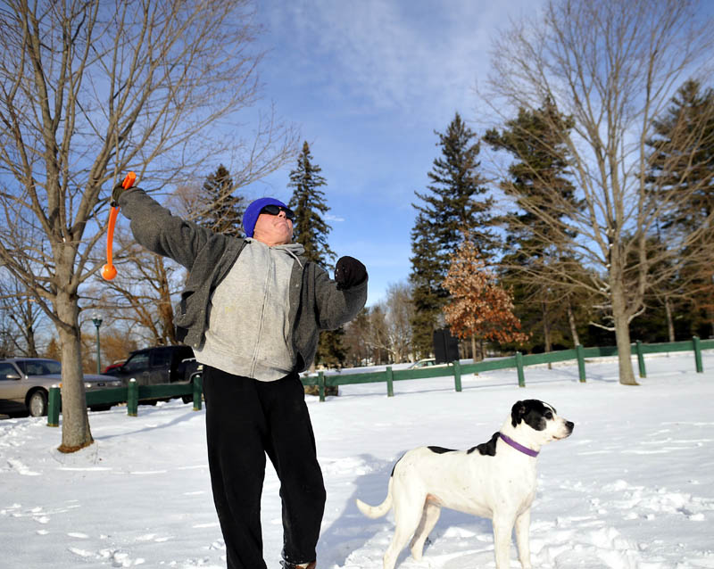 Jerry Ashlock, of Augusta, hurls a ball for his dogs on Thursday, in Augusta. Ashlock said his pair of rescue dogs need to "run around every day" to keep fit.