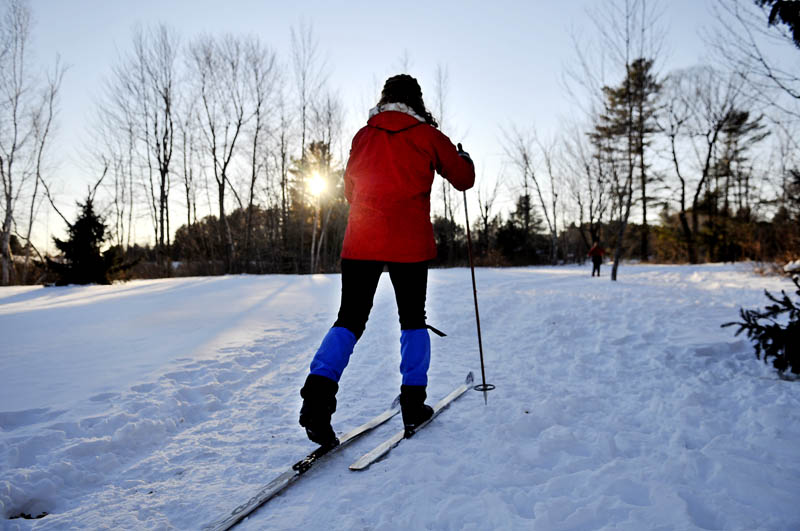 Christine Simpson, of Anchorage, Alaska, follows her husband, Eric, and mother-in-law, Karen Simpson, Wednesday while cross country skiing in Hallowell.