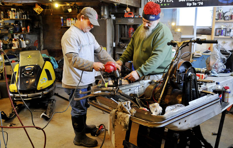Don Horne, right, and Richard Antanavich re-assemble the slide rails of a 1972 Arctic Cow Thursday in the Mount Vernon barn the vintage snowmobile racers use as a clubhouse. The men rebuild vintage snow machines to compete in races, at speeds up to 50 miles per hours, across New England. Cold weather this week kept them in the shop instead of riding the trails, Antanavich said.