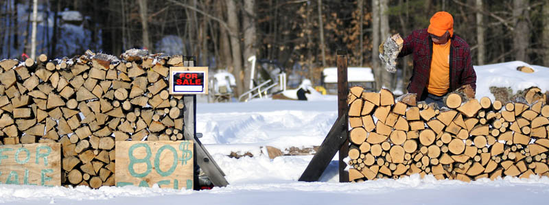 Richard Cormier piles firewood he cut at his Farmingdale lot, on Tuesday. Cormier said he's selling the freshly cut hardwood by the third of a cord.