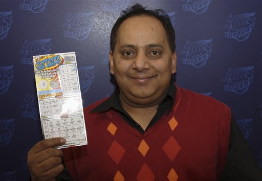 This photo provided by the Illinois Lottery shows Urooj Khan, 46, posing with a winning instant lottery ticket.