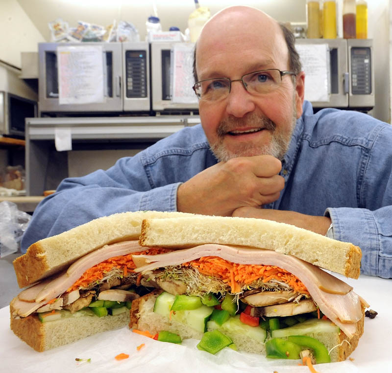 Gerry Michaud, co-owner of Big G's Deli on Benton Avenue in Winslow, poses next to his renamed sandwich, the 41,470, in recognition of the number of U.S. combat deaths in the Vietnam conflict. The sandwich was formerly named the Jane Fonda.
