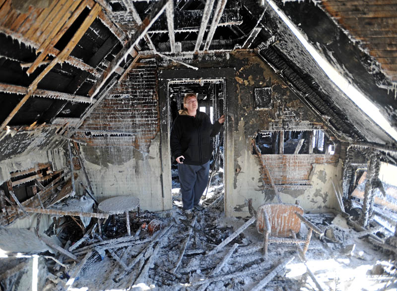Becky Williams, 40, inspects the ice-covered walls of the second floor of her parents' Madison home, which was destroyed by fire around 3 a.m. Friday morning. Officials believe the fire started near this room, because of faulty electrical wiring.