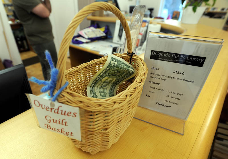 The "guilt basket" is displayed on the counter at the Belgrade Public Library on Depot Road in Belgrade on Tuesday. Instead of fining patrons for overdue library books, Belgrade Public Library imposes a sort of honor system for late returns.