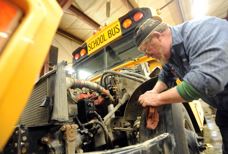Art Jones, a mechanic at the Regional School District 18 transportation facility, repairs a power steering pump on a district school bus in Oakland on Tuesday.
