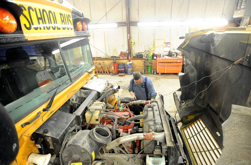 Art Jones, a mechanic at the Regional School District 18 transportation facility, repairs a power steering pump on a district school bus in Oakland on Tuesday.