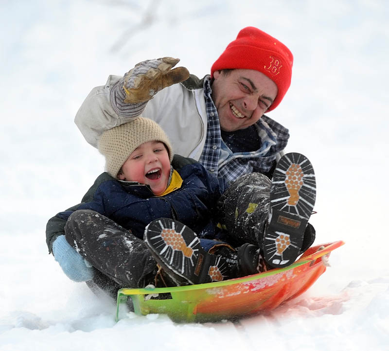 Randy Hawes and his son, Brady, 4, slide down the Sherwin Street hill in Waterville Thursday.